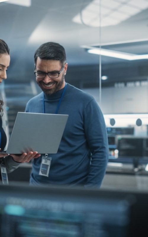 Portrait,Of,Two,Happy,Female,And,Male,Engineers,Using,Laptop